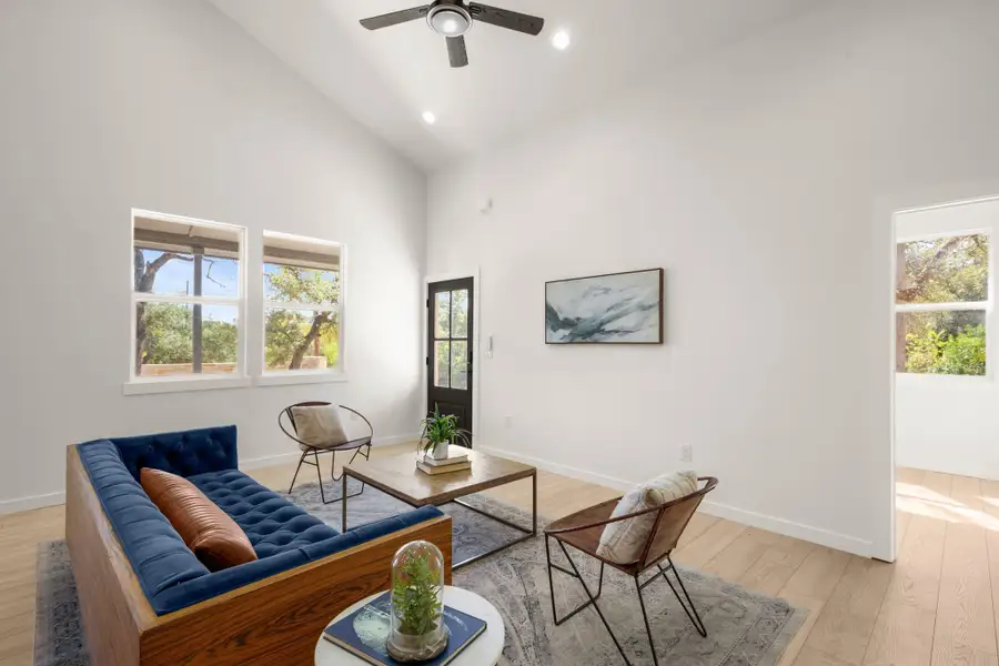 Living room featuring high vaulted ceiling, light wood-type flooring, recessed lighting, and a ceiling fan