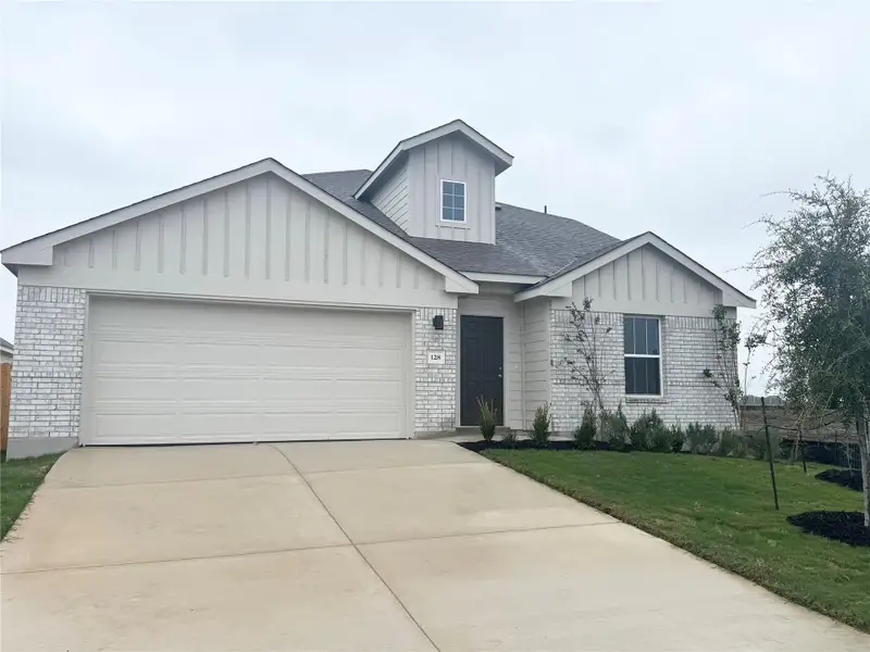 View of front of house with board and batten siding, a shingled roof, and brick siding View of front of house with board and batten siding, a shingled roof, and brick siding