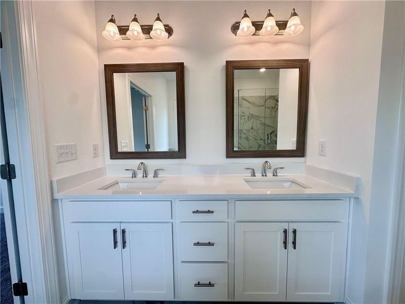 dual vanity features quartz countertops wtih frammed mirrors