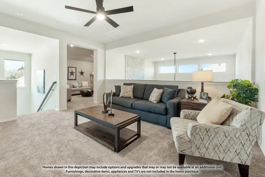 Upstairs living room with carpet, ceiling fan, gray sofa, and wood coffee table near staircase landing Upstairs living room with carpet, ceiling fan, gray sofa, and wood coffee table near staircase landing