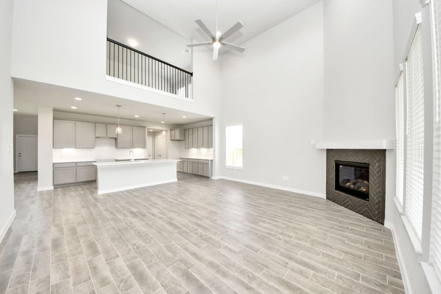 Gather the family and guests together in your lovely living room! Featuring soaring high ceilings, recessed lighting, ceiling fan, custom paint, gorgeous floors, and large windows that provide plenty of natural lighting throughout the day. Sample photo of completed home with similar floor plan. Actual colors and selections may vary. Gather the family and guests together in your lovely living room! Featuring soaring high ceilings, recessed lighting, ceiling fan, custom paint, gorgeous floors, and large windows that provide plenty of natural lighting throughout the day. Sample photo of completed home with similar floor plan. Actual colors and selections may vary.