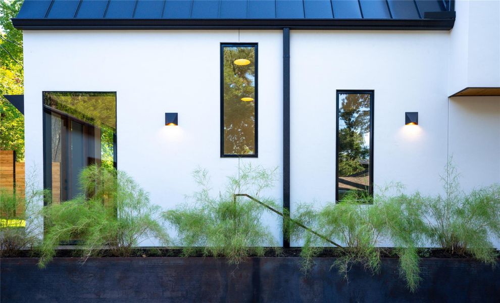 View of property exterior featuring a standing seam roof and stucco siding