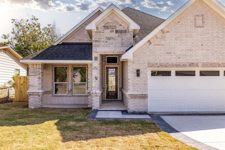 View of front of house featuring a front lawn and a garage