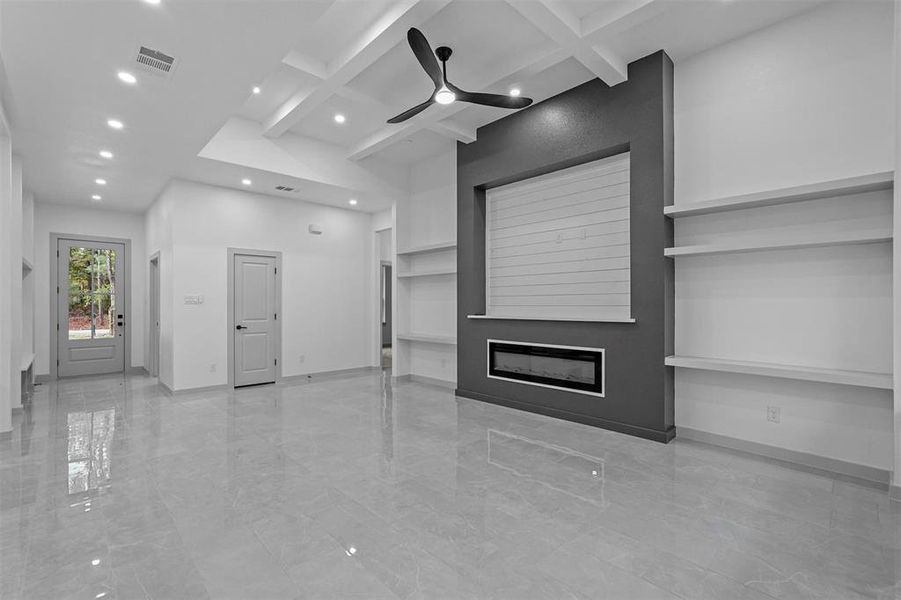 Unfurnished living room with beam ceiling, ceiling fan, and coffered ceiling