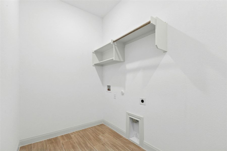 Washroom featuring gas dryer hookup, electric dryer hookup, wood tiled floors, and hookup for a washing machine Washroom featuring gas dryer hookup, electric dryer hookup, wood tiled floors, and hookup for a washing machine