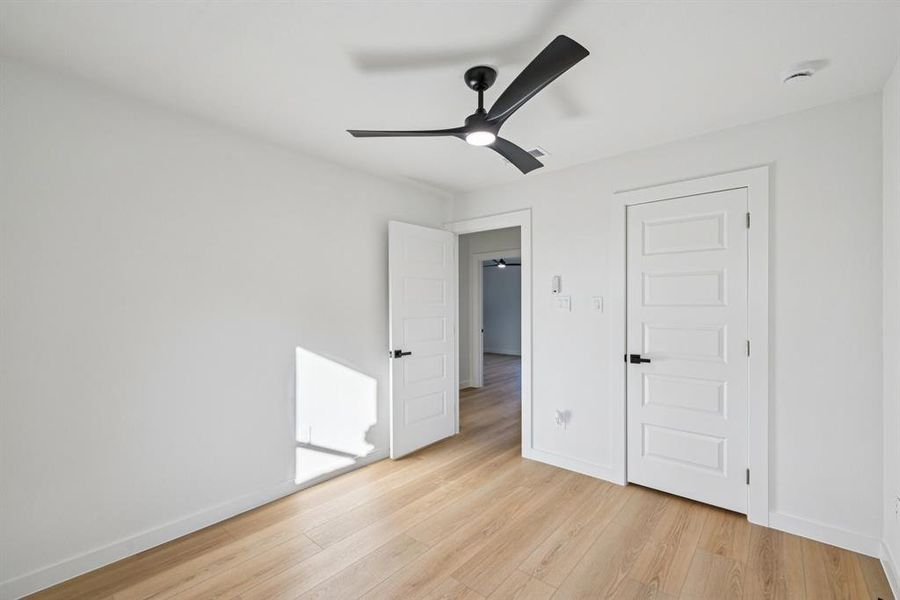 Unfurnished bedroom featuring light wood-style floors and a ceiling fan