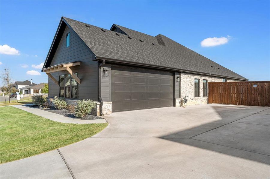 View of property exterior featuring a shingled roof, driveway, an attached garage, and brick siding View of property exterior featuring a shingled roof, driveway, an attached garage, and brick siding
