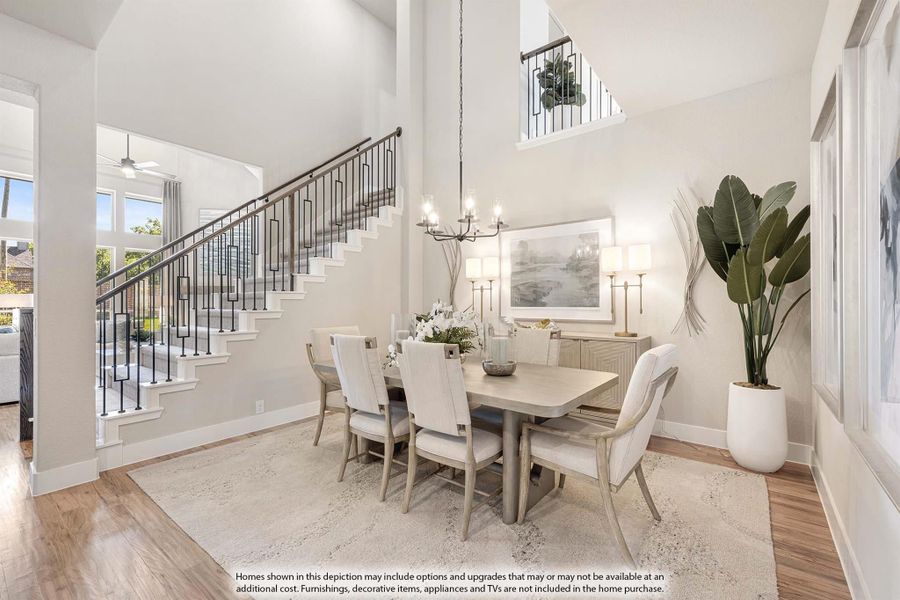 Formal dining room with two-story ceiling, staircase, chandelier, and six-seat table on hardwood floors