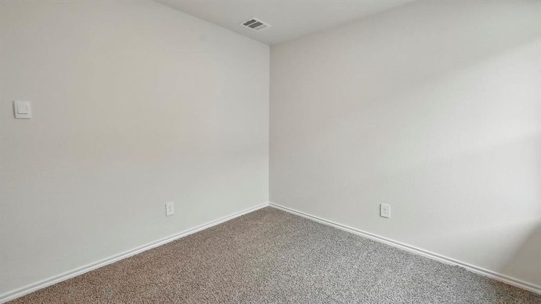 The room features light gray textured walls, a gray carpeted floor, and a white baseboard