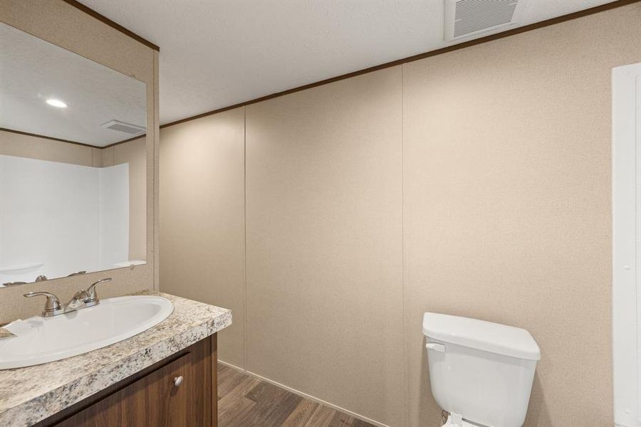 Bathroom featuring a vanity with a laminate countertop, undermount sink, and chrome fixtures