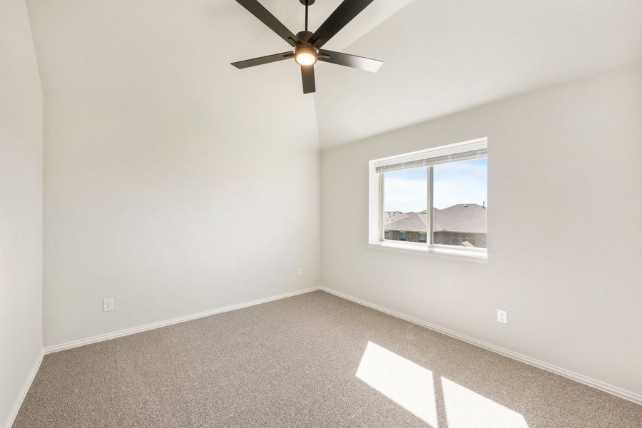Empty bedroom with vaulted ceiling, ceiling fan, carpet flooring, and single window