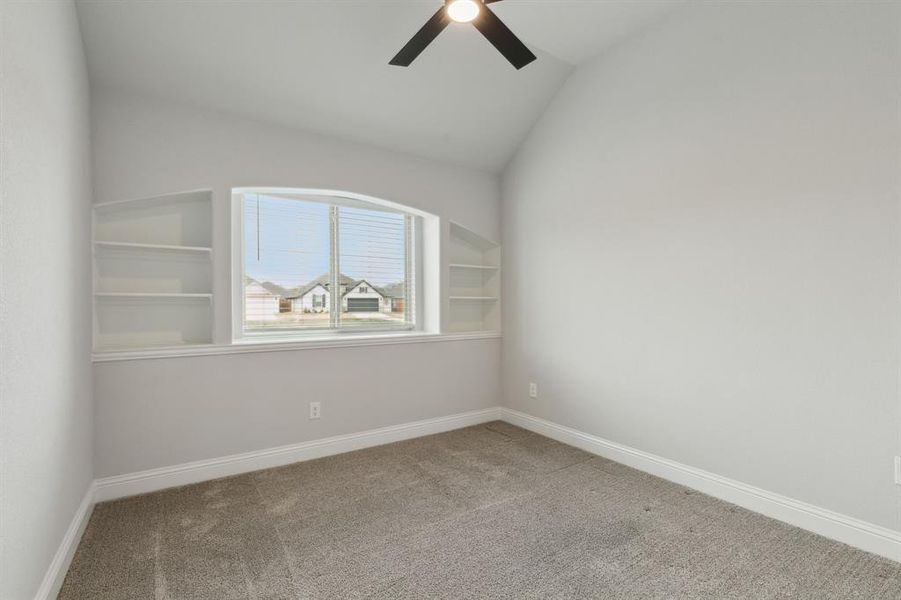 Secondary bedroom with custom built in bookshelves.