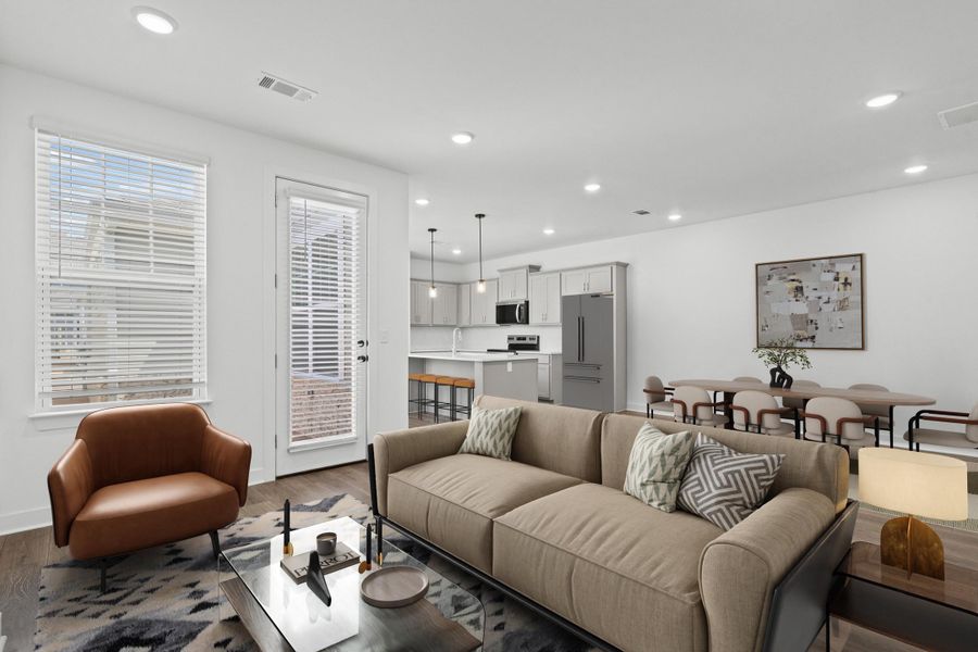 Open-concept living area featuring wood-finish flooring, recessed lighting, and a white color palette