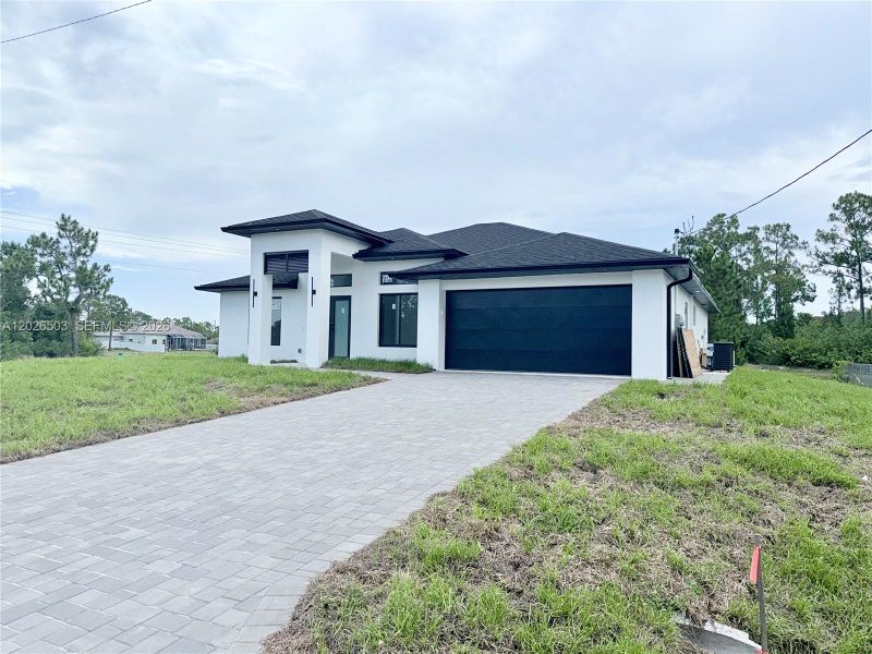 Front exterior of a new home in , Lehigh Acres, FL, highlighting curb appeal (Image 21).