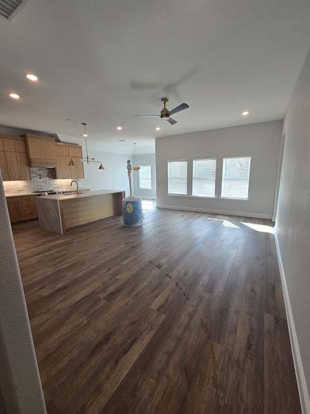 Unfurnished living room with dark wood-style floors, a ceiling fan, and recessed lighting