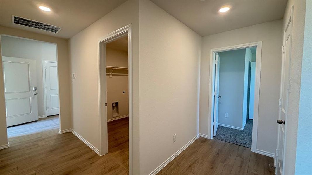 Hallway with wood-finish flooring, recessed lighting, and white baseboards
