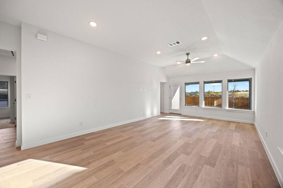 A spacious room offers ample natural light and durable wood flooring.