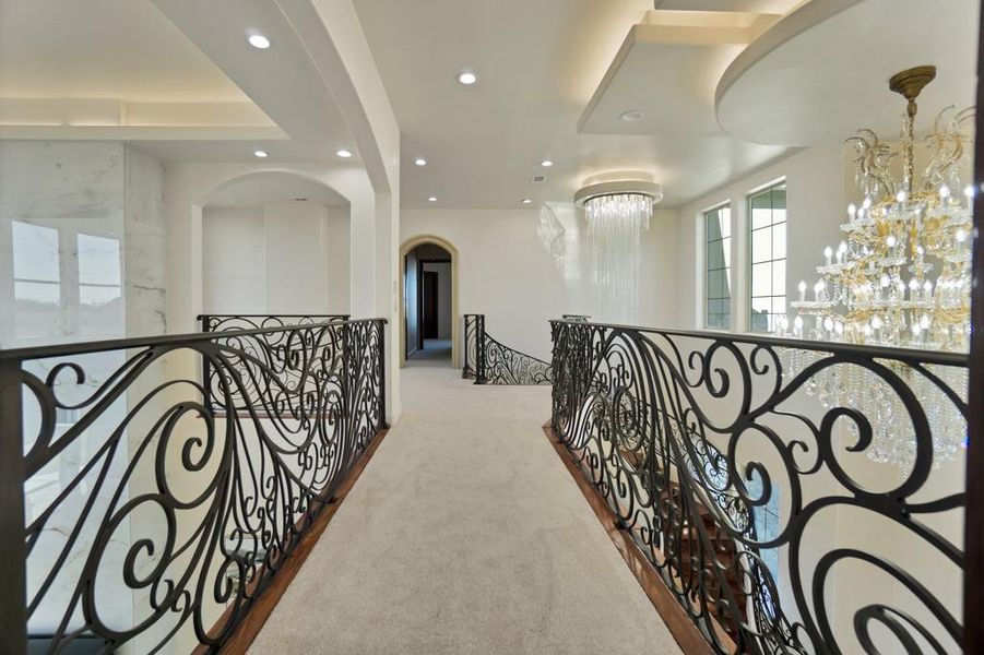 Hall featuring an inviting chandelier and light carpet