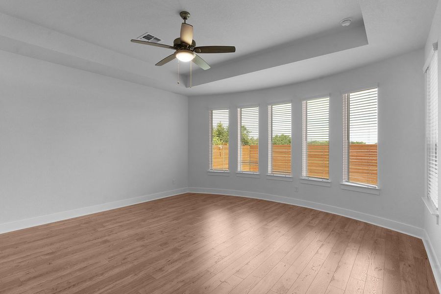 Well-lit living area featuring rich wood flooring and a refreshing ceiling fan.