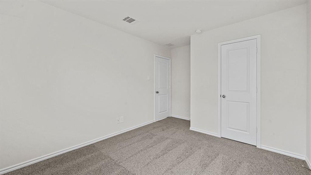 Carpeted room featuring white walls, white two-panel interior doors, and white baseboards
