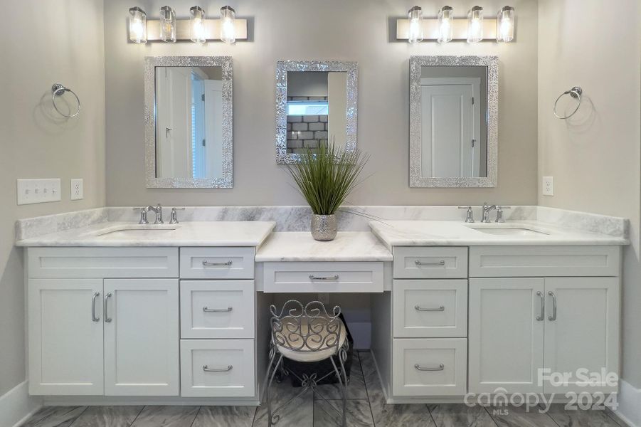 Owners bath with a 96" vanity, upgraded counters and fixtures, stylish mirrors and lighting