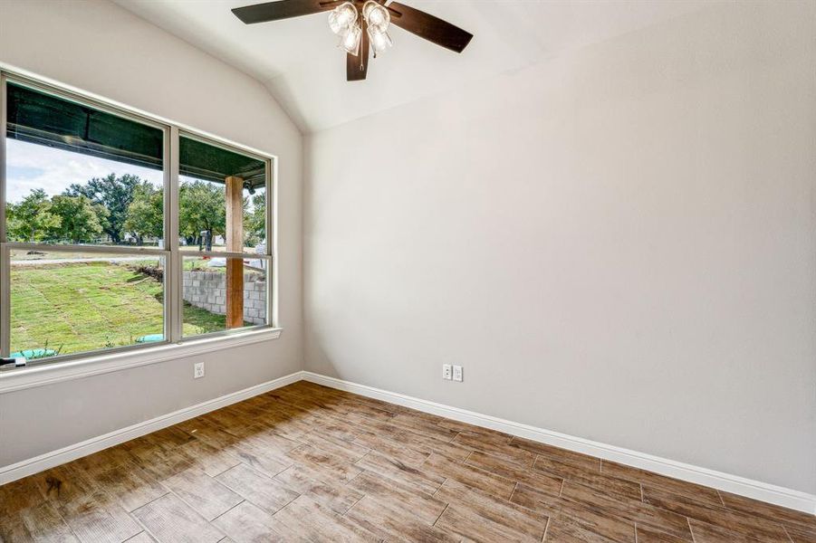 Spare room with ceiling fan and vaulted ceiling