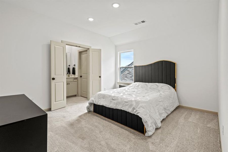 Bedroom with light colored carpet, lofted ceiling, and recessed lighting