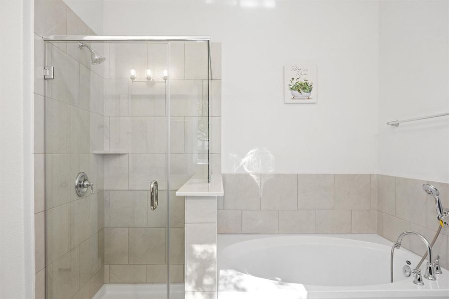 Bathroom featuring a stall shower and a garden tub Bathroom featuring a stall shower and a garden tub