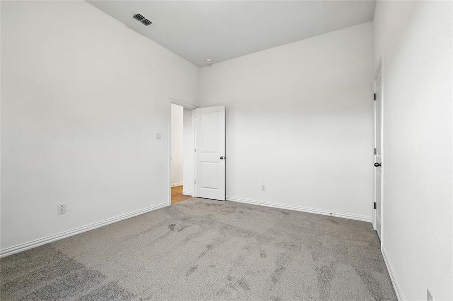Unfurnished room featuring light carpet and baseboards