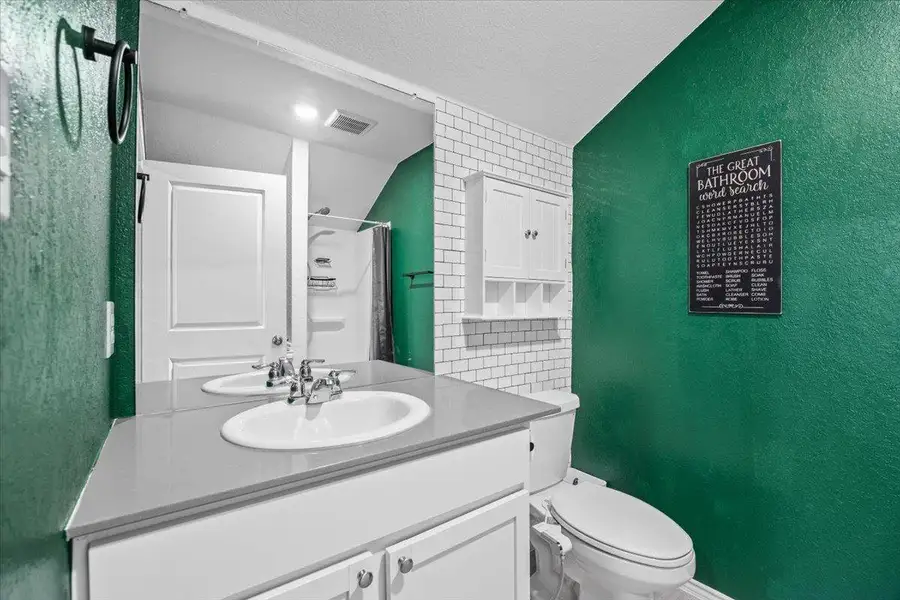 Full bath with vanity, a shower with shower curtain, a textured wall, and a textured ceiling Full bath with vanity, a shower with shower curtain, a textured wall, and a textured ceiling