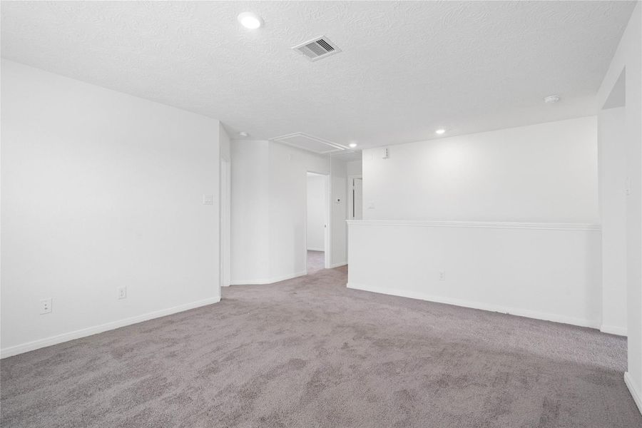 Additional view from the Loft looking towards staircase, entrance to primary suite on the right, and secondary bedrooms and bathroom to the left.