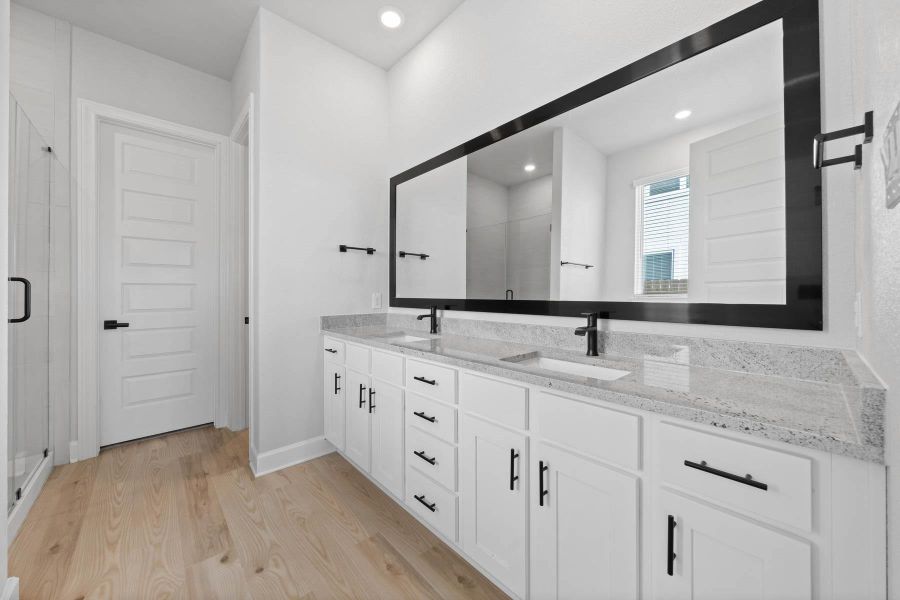 Master bathroom includes granite countertop, elongated mirror, and dual-vanity sinks.