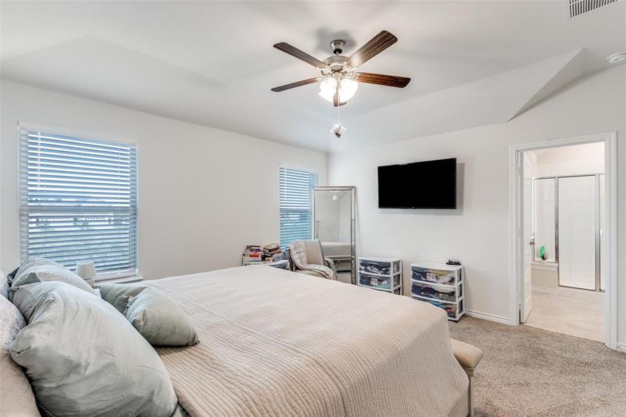 Bedroom featuring carpet flooring, multiple windows, and a ceiling fan Bedroom featuring carpet flooring, multiple windows, and a ceiling fan