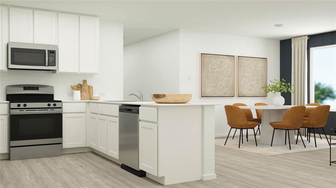 Kitchen featuring a peninsula, stainless steel appliances, light countertops, white cabinetry, and a sink