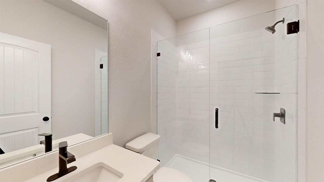 Full bath with a stall shower, vanity, and a textured wall Full bath with a stall shower, vanity, and a textured wall