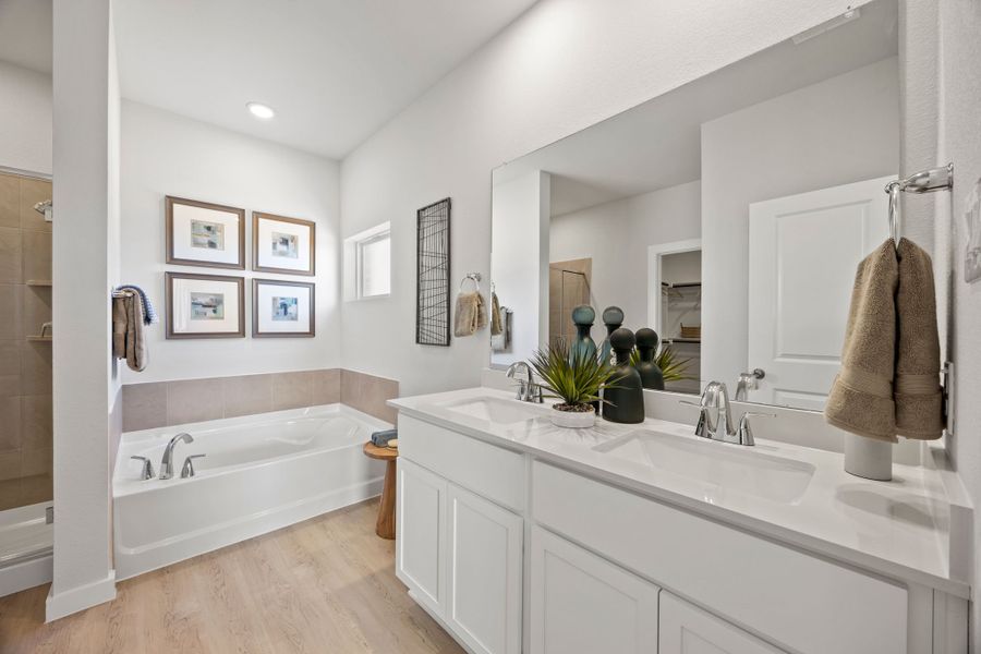 A bathroom with a tub sink and mirror.