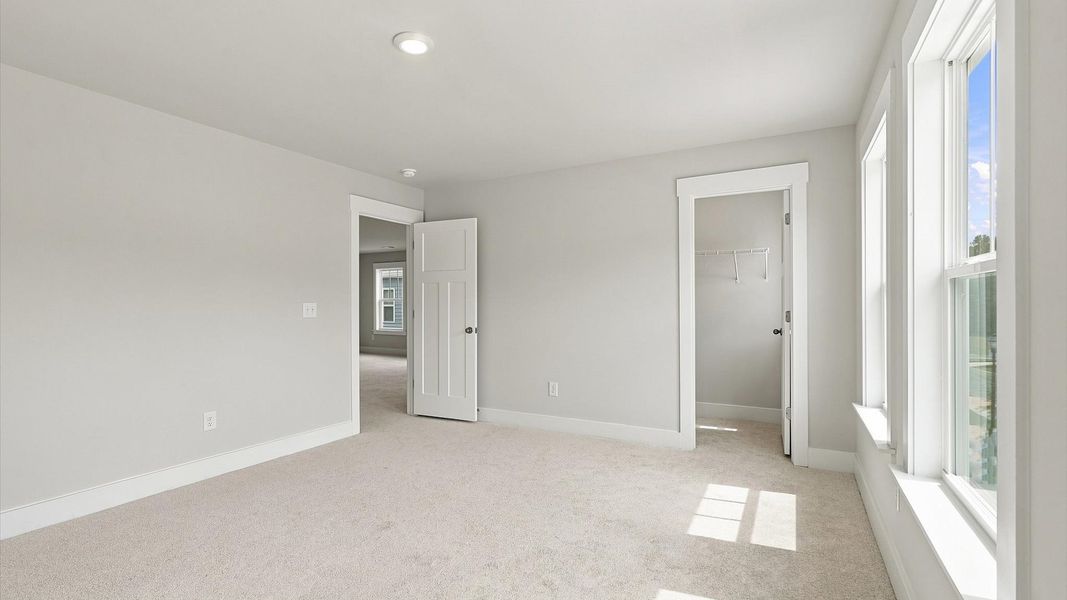 Highly functional bedroom with walk-in closet and tasteful carpet for a restful retreat Highly functional bedroom with walk-in closet and tasteful carpet for a restful retreat