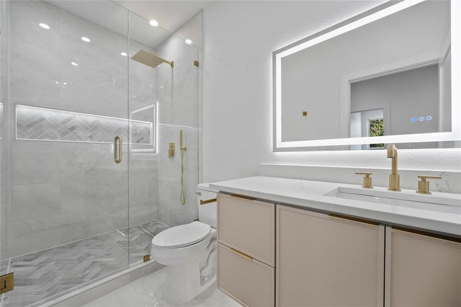 Bathroom with vanity, toilet, and a shower with shower door