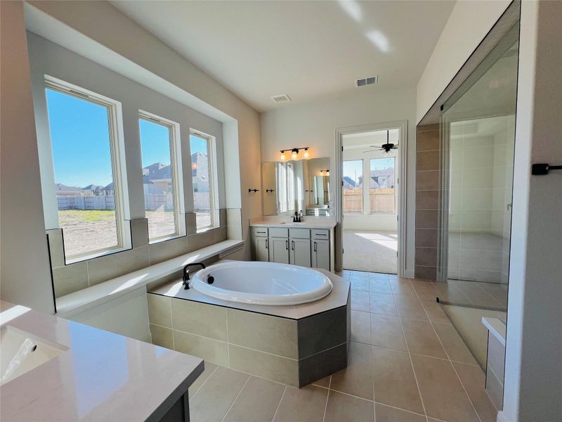 Full bathroom featuring vanity, a bath, light tile patterned floors, and ceiling fan
