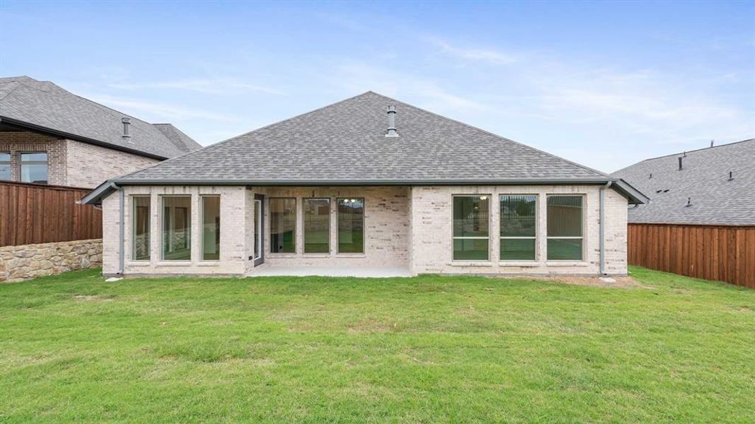 Rear view of house featuring a patio area and a lawn