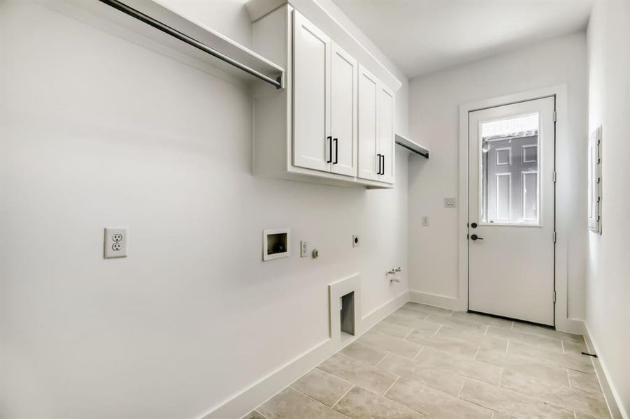 Laundry room featuring hookup for a gas dryer, cabinet space, washer hookup, hookup for an electric dryer, and light tile patterned flooring
