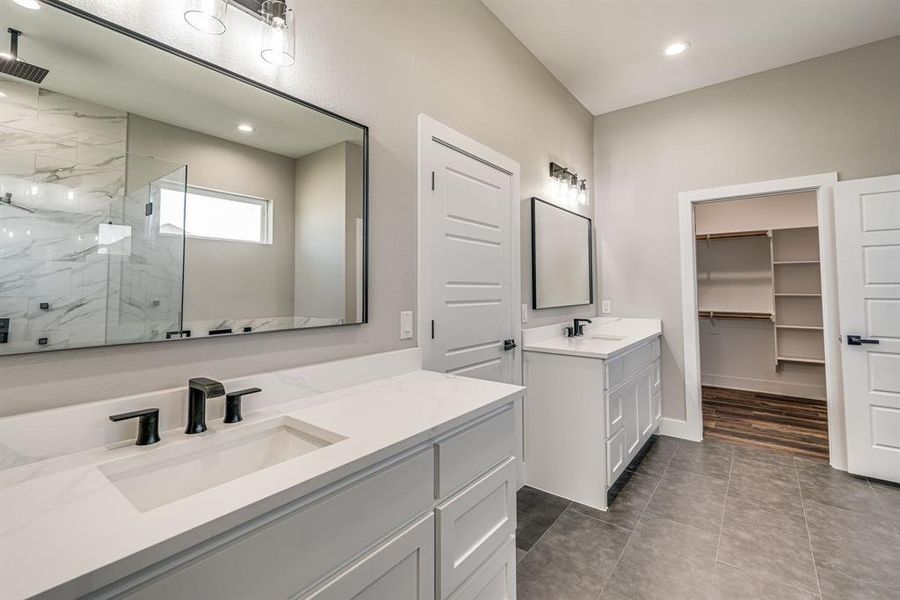 Bathroom featuring vanity, tile patterned flooring, and walk in shower