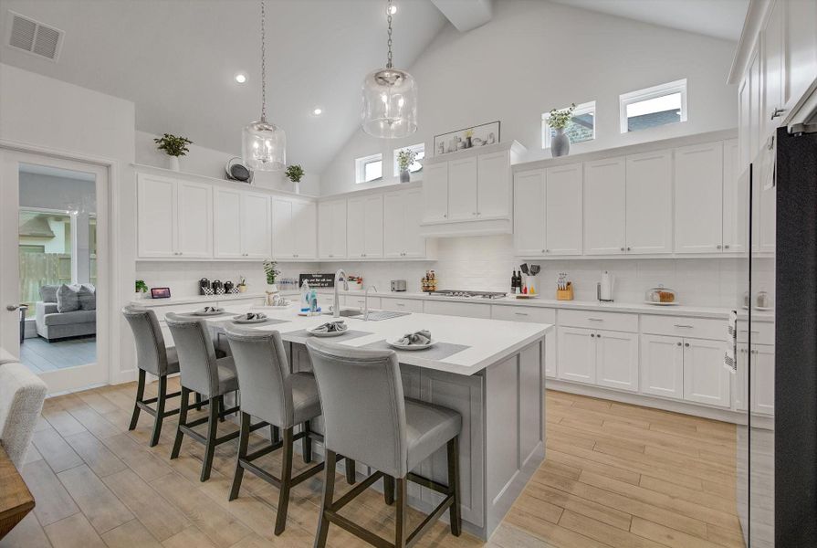 The gourmet kitchen is a culinary haven, featuring a large island, a spacious pantry, and designer finishes that elevate both style and function.