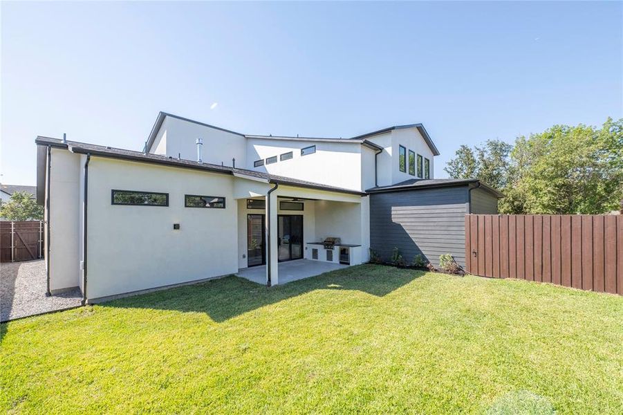 Rear view of house with a yard and a patio area