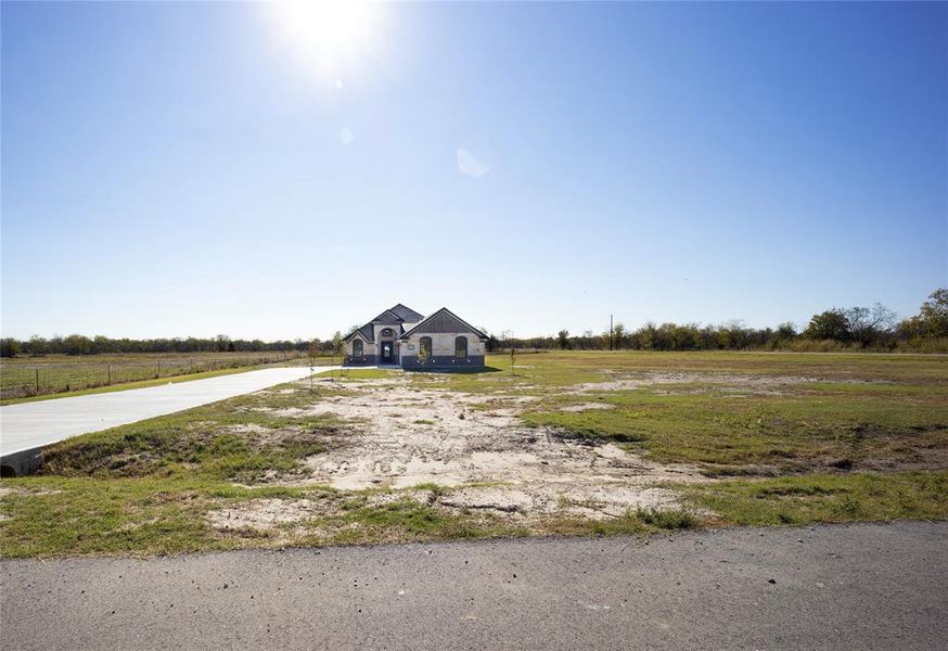 French country inspired facade with a view of rural / pastoral area and driveway