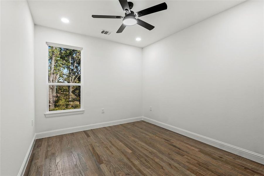 Empty room featuring dark wood-type flooring, recessed lighting, and a ceiling fan