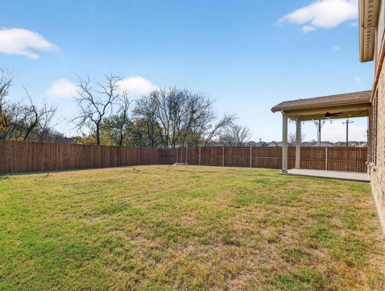 Fenced backyard with a patio area