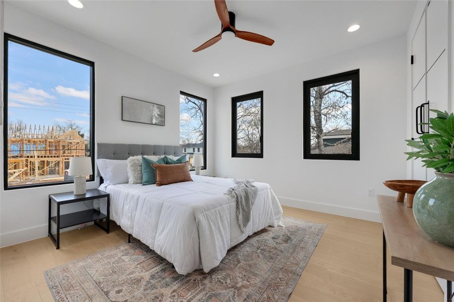 Bedroom with light wood-style flooring, ceiling fan, and recessed lighting