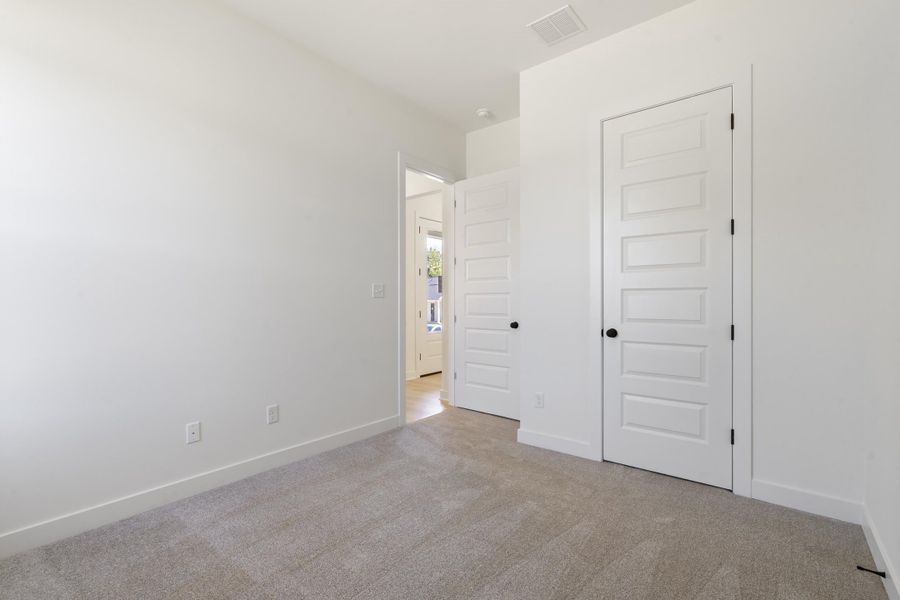 Neutral interior featuring wall-to-wall carpeting, five-panel shaker-style interior doors, and matte black door hardware Neutral interior featuring wall-to-wall carpeting, five-panel shaker-style interior doors, and matte black door hardware