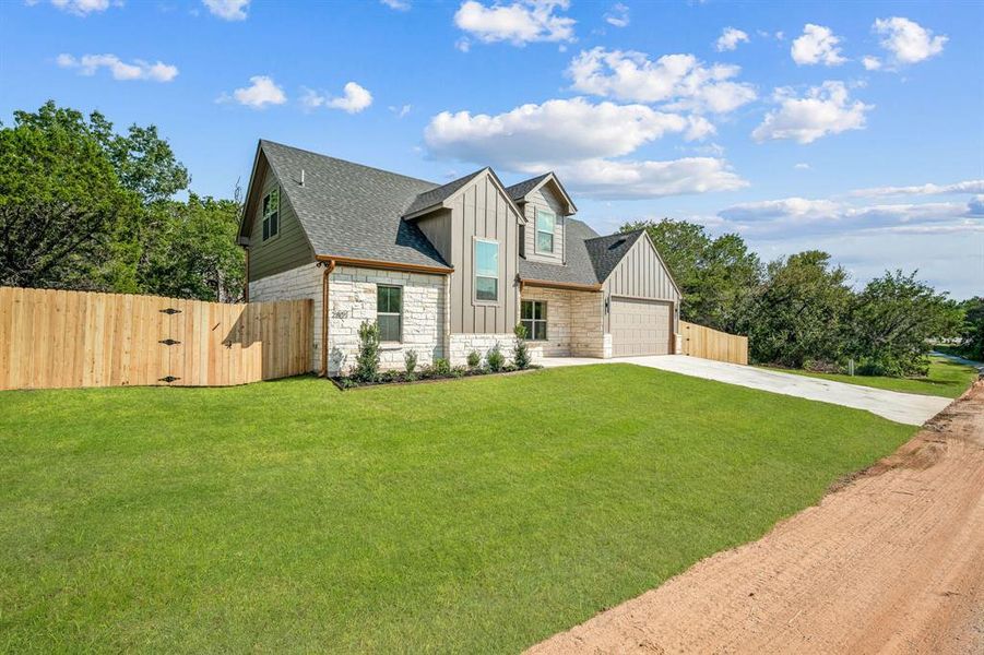 View of front of property featuring a front yard and a garage